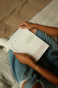 Load image into Gallery viewer, Person holding a notepad on a bed with a neutral background - Thread Vision Spotlight, Ignited Apparel
