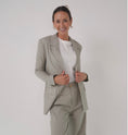 Load image into Gallery viewer, Woman wearing a light gray suit with a white shirt on a plain background - Thread Vision Spotlight, Loe Hayley
