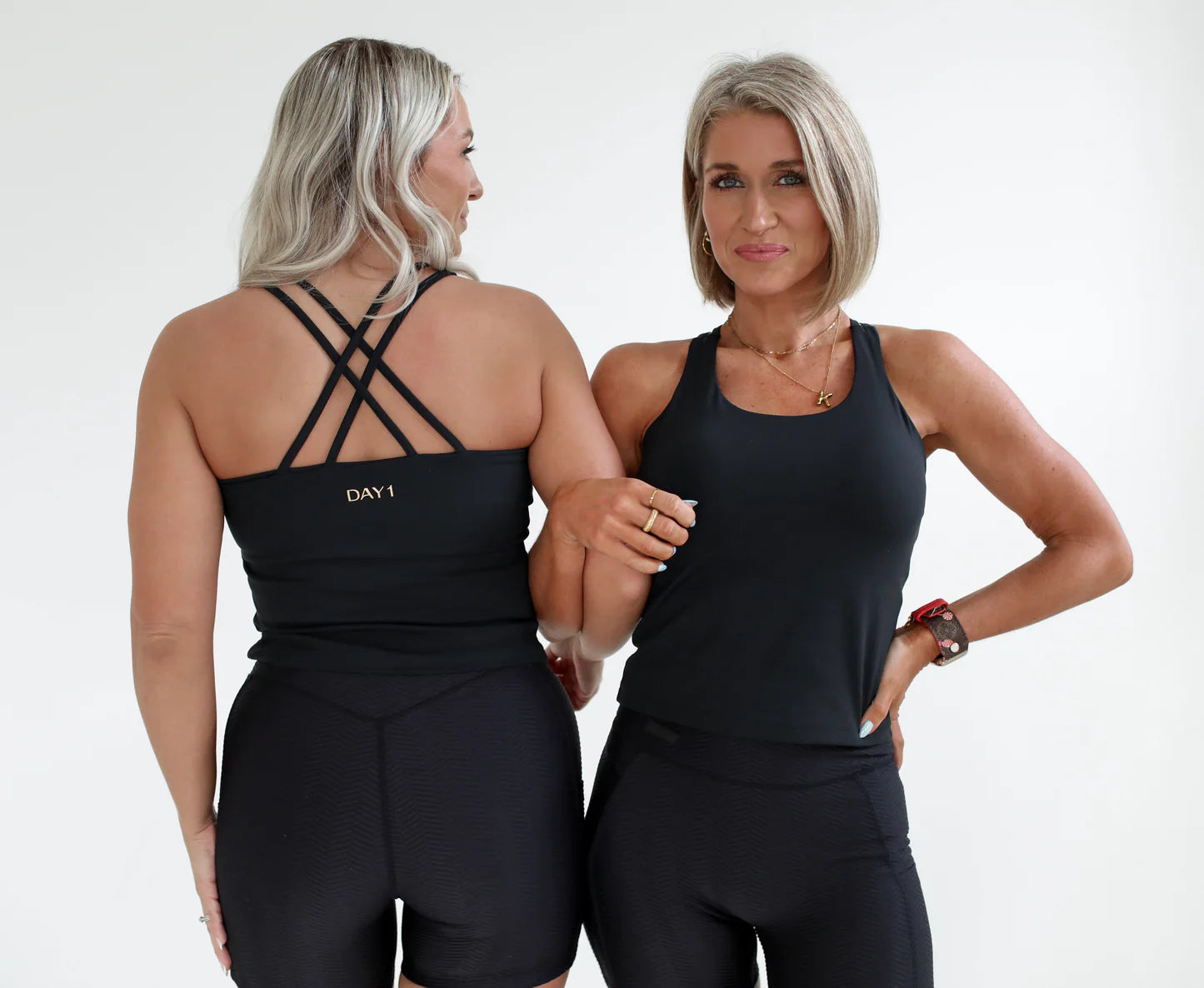 Two women wearing black athletic outfits with 'DAY 1 FITNESS' branding on a white background - - Thread Vision Spotlight, Day 1 Fitness, Kaylee Rogers 