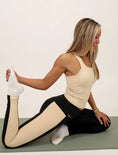 Load image into Gallery viewer, Woman in a yoga pose on a mat with a plain background - Thread Vision Spotlight, Day 1 Fitness, Kaylee Rogers 
