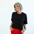 Load image into Gallery viewer, Woman wearing a black top with red trim and a red skirt on a white background - Thread Vision Spotlight, Day 1 Fitness, Kaylee Rogers 
