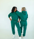 Load image into Gallery viewer, Two people wearing matching green sweatshirt and sweatpants against a white background - Thread Vision Spotlight, Day 1 Fitness, Kaylee Rogers 
