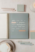 Load image into Gallery viewer, Notebook with motivational quote on a light surface with stationery items  - Thread Vision Spotlight, PCOS Planner
