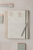 Load image into Gallery viewer, Spiral-bound planner with pen on a light surface - Thread Vision Spotlight, PCOS Planner
