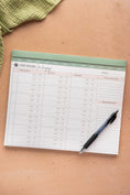 Load image into Gallery viewer, Notepad with a planner layout on a brown surface with a pen beside it - Thread Vision Spotlight, Oh Snap Macros
