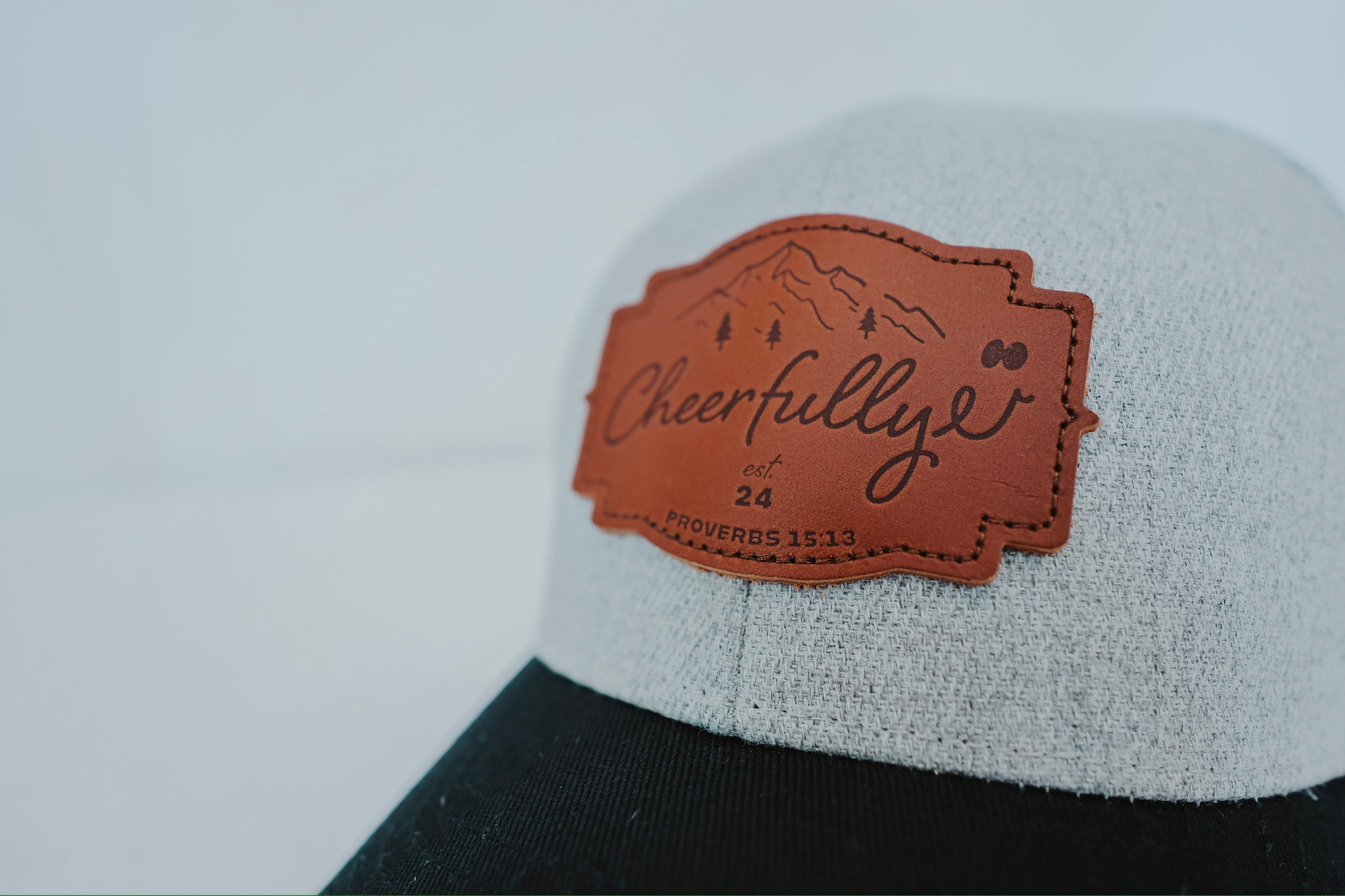 Cap with a leather patch featuring the brand 'Cheerfully' on a white background - Thread Vision Client Spotlight, Cheerfully U by Alyssa Webster 