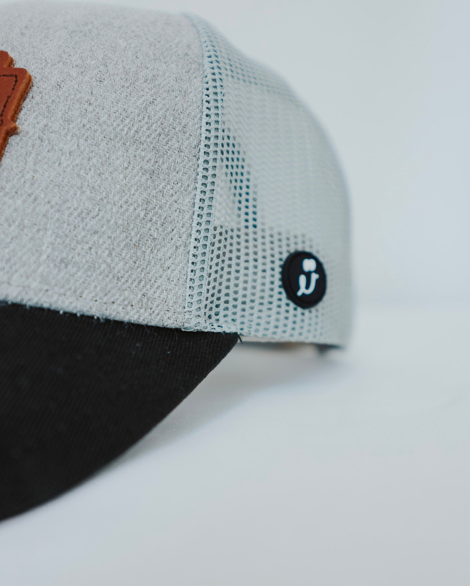 Gray and black cap with a logo on a light gray background - Thread Vision Client Spotlight, Cheerfully U by Alyssa Webster 